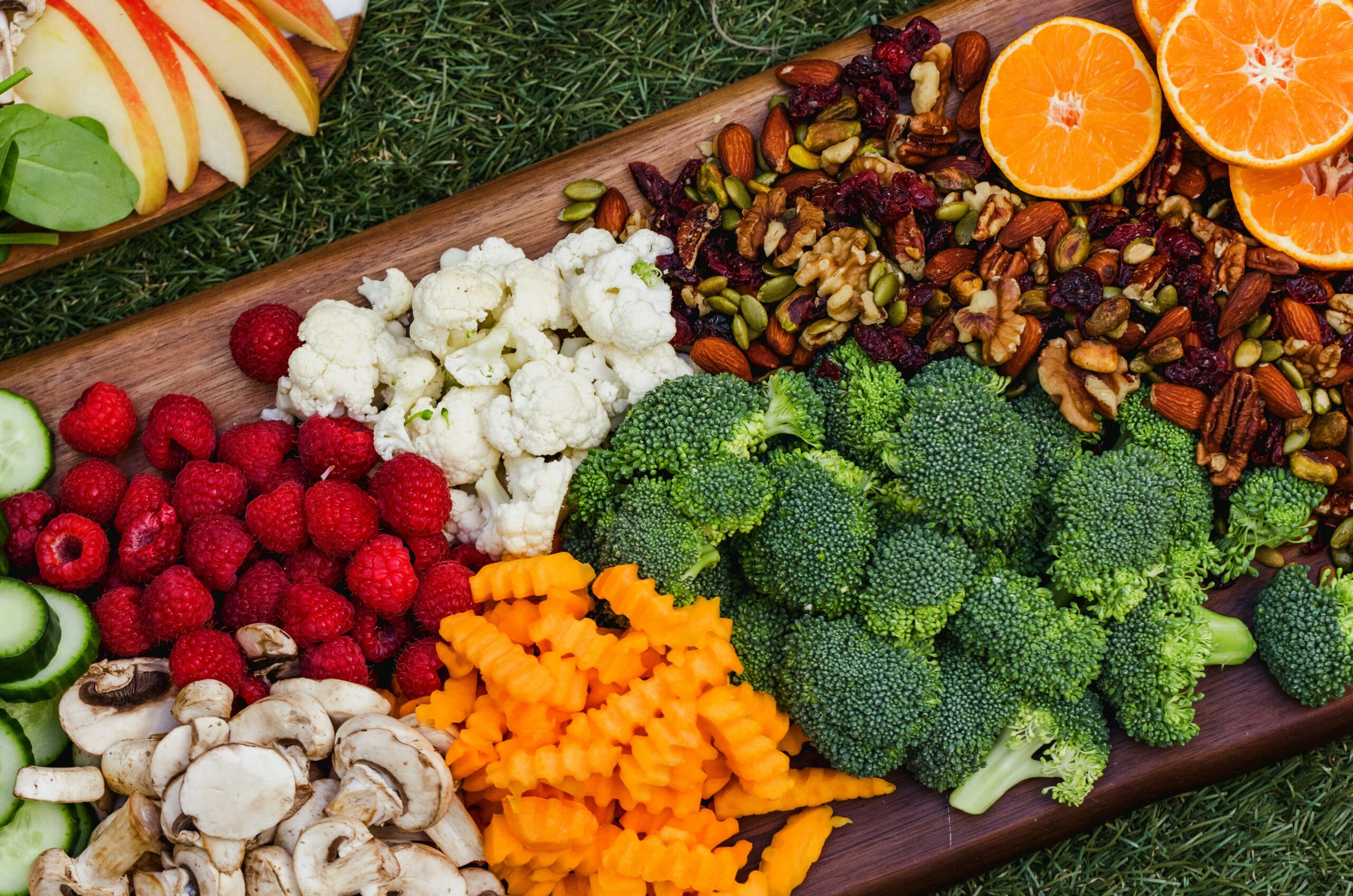 Board with vegetables, fruits, and nuts, cauliflower, carrots, broccoli,